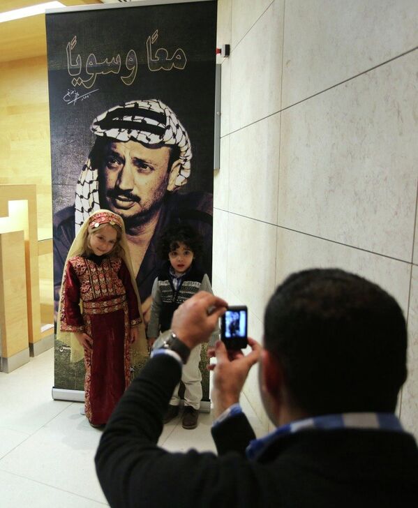 Children pose for a picture in front of Yasser Arafat poster during the opening of a museum for Arafat in the West Bank city of Ramallah on Sunday, Nov. 9, 2014. - Sputnik International
