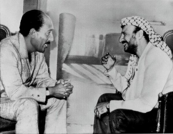 Egyptian President Anwar Sadat, left, chats with Palestinian leader Yasser Arafat in Cairo, June 1, 1974, before the start of the opening session of the Palestinian Parliament in exile - Sputnik International