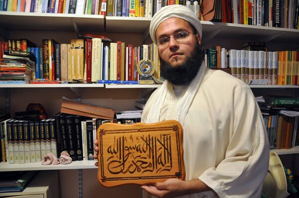 In this photo taken Sep. 10, 2010, Alvaro Franco, 28, a Colombian permanent resident in the United States who converted to Islam 14 years ago, holding a wooden tablet with an Arabic inscription from the Quran, poses for pictures, at his home in New Jersey. In this photo taken Sep. 10, 2010, Alvaro Franco, 28, a Colombian permanent resident in the United States who converted to Islam 14 years ago, holding a wooden tablet with an Arabic inscription from the Quran, poses for pictures, at his home in New Jersey. - Sputnik International