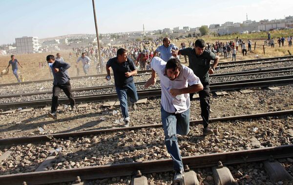 Turkish and Syrian Kurds run as Turkish security forces use tear gas to disperse them near the Mursitpinar border crossing on the Turkish-Syrian border, near the southeastern town of Suruc . file photo  - Sputnik International