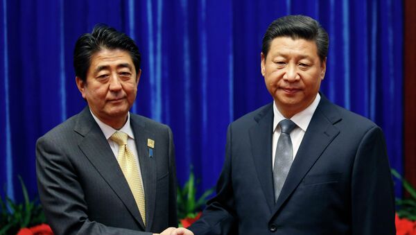 Japan's Prime Minister Shinzo Abe, left, and China's President Xi Jinping, right, shake hands during their meeting at the Great Hall of the People, on the sidelines of the Asia-Pacific Economic Cooperation (APEC) summit, in Beijing, Monday, Nov. 10, 2014. An uneasy handshake Monday between Xi and Abe marked the first meeting between the two men since either took power, and an awkward first gesture toward easing two years of high tensions. - Sputnik International
