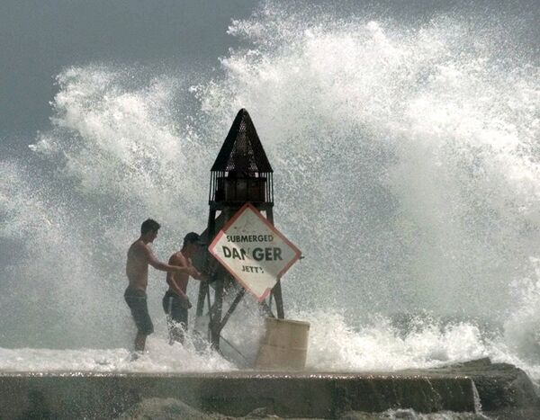 This Sept 14, 1999 file photo shows Fort Lauderdale, Fla., residents Rafael Verga, left, and Joel Vasconcelos, right, holding on as waves hit the jetty at Haulover Beach in Miami Beach, Fla., as Hurricane Floyd moves toward South Florida. Sea levels rising because of global warming, along with increased storminess as the climate changes, will expose tens of millions of people in the world's port cities to coastal flooding, says a report by the Organization for Economic Cooperation and Development. This Sept 14, 1999 file photo shows Fort Lauderdale, Fla., residents Rafael Verga, left, and Joel Vasconcelos, right, holding on as waves hit the jetty at Haulover Beach in Miami Beach, Fla., as Hurricane Floyd moves toward South Florida. Sea levels rising because of global warming, along with increased storminess as the climate changes, will expose tens of millions of people in the world's port cities to coastal flooding, says a report by the Organization for Economic Cooperation and Development. - Sputnik International