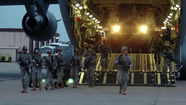 Soldiers from the 2nd Platoon, Alpha Company, 1-27 Infantry Division, assume a security perimeter as two M1126 Stryker Infantry Carrier Vehicles exit a C-17 Globemaster and drive onto the tarmac at Daegu Air Base, South Korea - Sputnik International
