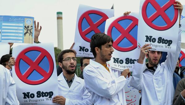 Iranian students hold placards to show their support for Iran's nuclear program in a gathering in front of the headquarters of Iran's Atomic Energy Organization in Tehran, Iran, Sunday, Nov. 23, 2014 - Sputnik International