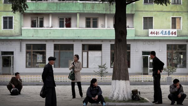 North Koreans wait at a roadside for public transport in downtown Pyongyang, North Korea - Sputnik International