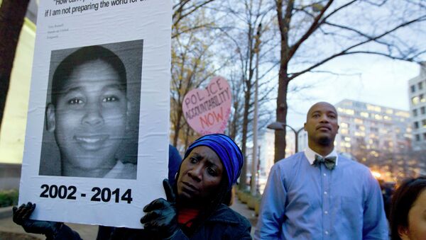 A protester holds a picture of Tamir Rice, the boy fatally shot by a rookie police officer, during a protest in response to a grand jury's decision in Ferguson to not indict police officer Darren Wilson. Protesters across the U.S. have walked off their jobs or away from classes in support of the Ferguson protesters. Rice's death has also sparked community demonstrations against police shootings. - Sputnik International