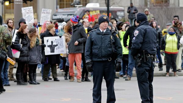 Police officers monitor demonstrators blocking Public Square in Cleveland Tuesday, Nov. 25, 2014, during a protest over the weekend police shooting of Tamir Rice. The 12-year-old was fatally shot by a Cleveland police officer Saturday after he reportedly pulled a replica gun at the city park. - Sputnik International