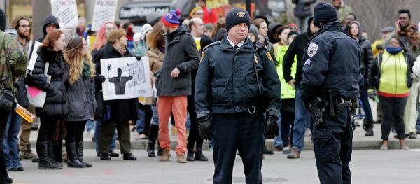 Police officers monitor demonstrators blocking Public Square in Cleveland Tuesday, Nov. 25, 2014, during a protest over the weekend police shooting of Tamir Rice. The 12-year-old was fatally shot by a Cleveland police officer Saturday after he reportedly pulled a replica gun at the city park. - Sputnik International