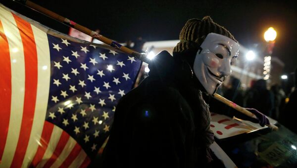A protester wearing a Guy Fawkes mask carries an American flag outside the Ferguson Police Department in Ferguson, Missouri, November 24, 2014 - Sputnik International