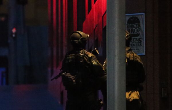 Armed tactical response police personnel stand watch into the evening near a cafe under siege by a gunman at Martin Place in the central business district of Sydney, Australia Armed tactical response police personnel stand watch into the evening near a cafe under siege by a gunman at Martin Place in the central business district of Sydney, Australia - Sputnik International