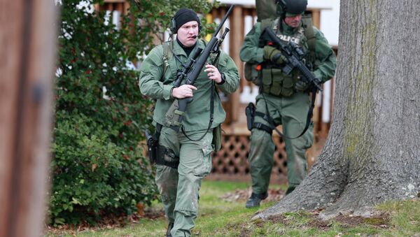 Police move near a home Monday, Dec. 15, 2014, in Souderton, PA, where a suspect was believed to have barricaded himself inside after shootings at multiple homes. Police tell WPVI-TV the man is suspected of killing at least five people Monday morning at three different homes northwest of Philadelphia. - Sputnik International