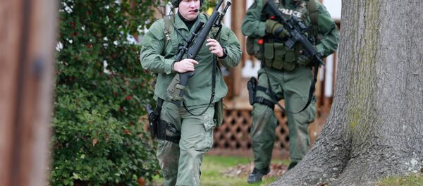 Police move near a home Monday, Dec. 15, 2014, in Souderton, PA, where a suspect was believed to have barricaded himself inside after shootings at multiple homes. Police tell WPVI-TV the man is suspected of killing at least five people Monday morning at three different homes northwest of Philadelphia. - Sputnik International