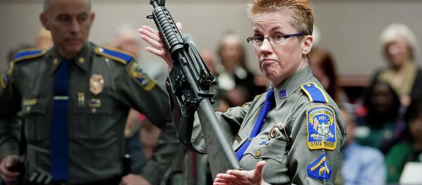 In this Jan. 28, 2013, file photo, firearms training unit Detective Barbara J. Mattson, of the Connecticut State Police, holds up a Bushmaster AR-15 rifle, the same make and model of gun used by Adam Lanza in the Sandy Hook School shooting, for a demonstration during a hearing of a legislative subcommittee reviewing gun laws, at the Legislative Office Building in Hartford, Connecticut. In this Jan. 28, 2013, file photo, firearms training unit Detective Barbara J. Mattson, of the Connecticut State Police, holds up a Bushmaster AR-15 rifle, the same make and model of gun used by Adam Lanza in the Sandy Hook School shooting, for a demonstration during a hearing of a legislative subcommittee reviewing gun laws, at the Legislative Office Building in Hartford, Connecticut. - Sputnik International