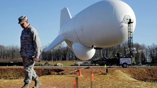 NORAD's Air Force Col. Chuck Douglass walks in front of an unmanned aerostat that is part of a new U.S. military cruise-missile defense system during a media preview, Wednesday, Dec. 17, 2014, in Middle River, Md. Military officials said a pair of helium-filled aerostats stationed in Maryland are intended provide early detection of cruise missiles over a large swath of the East Coast, from Norfolk, Va., to upstate New York, during a three-year test. JLENS, short for Joint Land Attack Cruise Missile Defense Elevated Netted Sensor System, will be fully implemented this winter. - Sputnik International