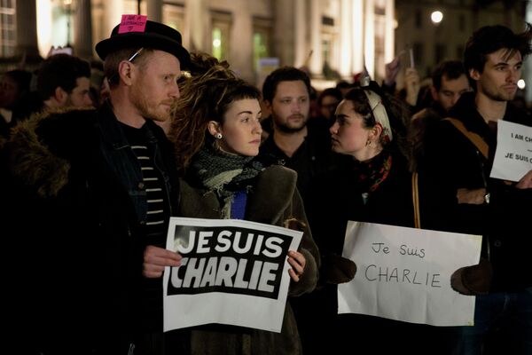 People hold up posters reading 'I am Charlie' in French as they take part in a vigil of people, including many who were French, to show solidarity with those killed in an attack on Charlie Hebdo - Sputnik International