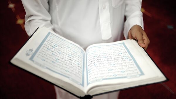 An imam holds the Quran after a prayer at a mosque - Sputnik International