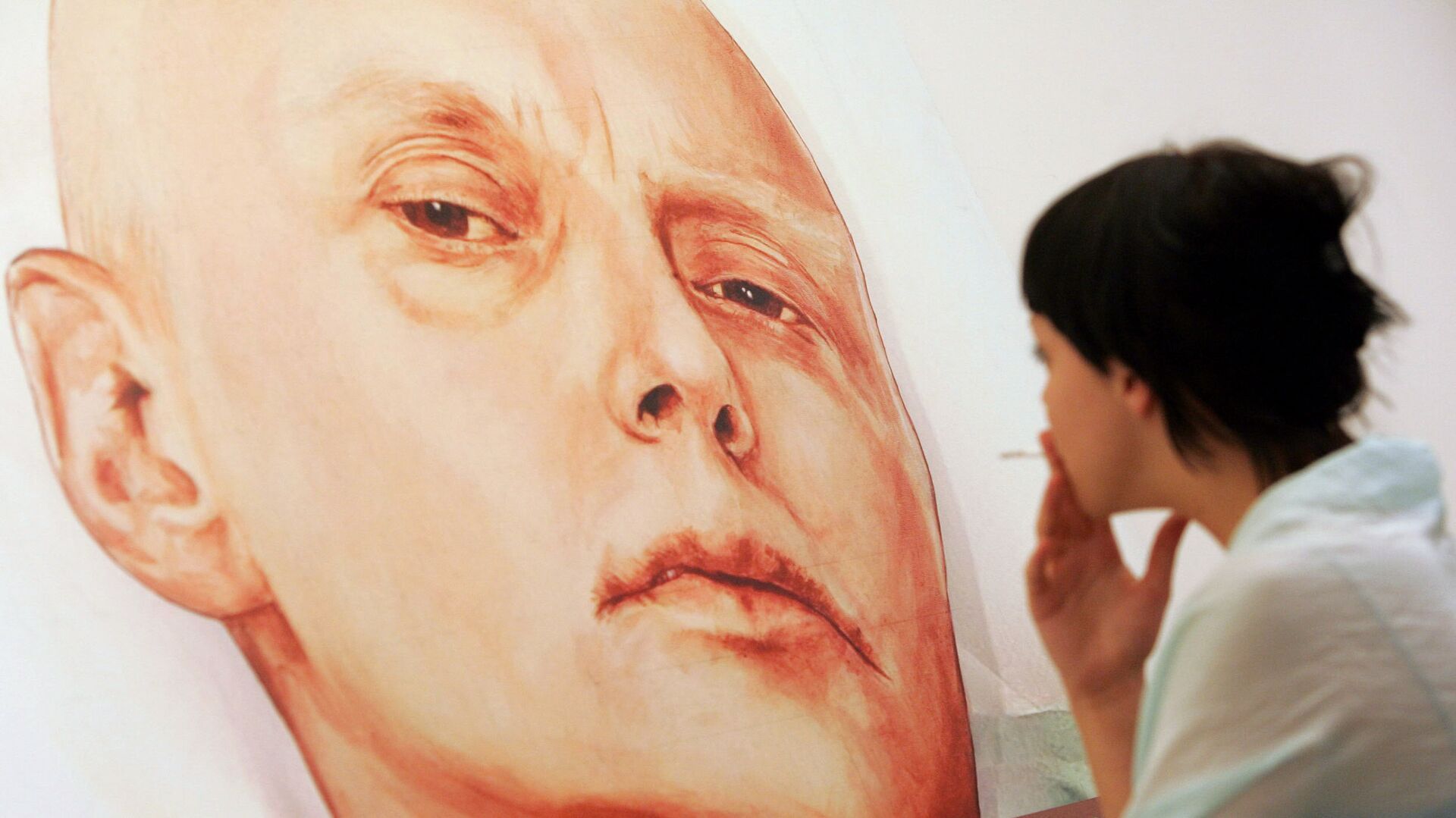 An art gallery visitor looks at a painting showing Alexander Litvinenko - Sputnik International, 1920, 21.09.2021