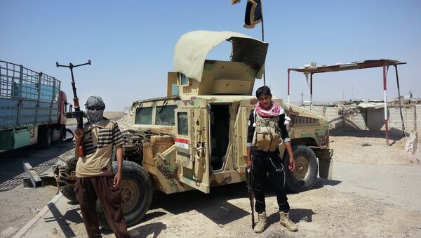 In this file photo, Islamic State group militants stand with a captured Iraqi army Humvee at a checkpoint outside Beiji refinery, around 155 miles north of Baghdad, Iraq. - Sputnik International
