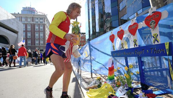 A runner pays his respects at a makeshift memorial honoring to the victims of the 2013 Boston Marathon bombings. - Sputnik International