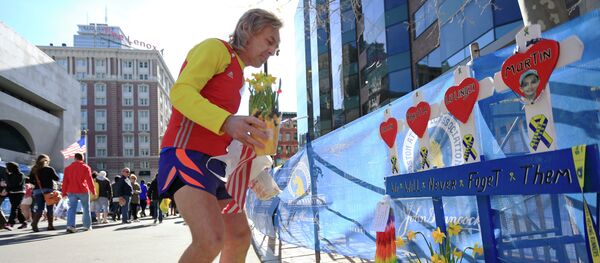 A runner pays his respects at a makeshift memorial honoring to the victims of the 2013 Boston Marathon bombings. - Sputnik International