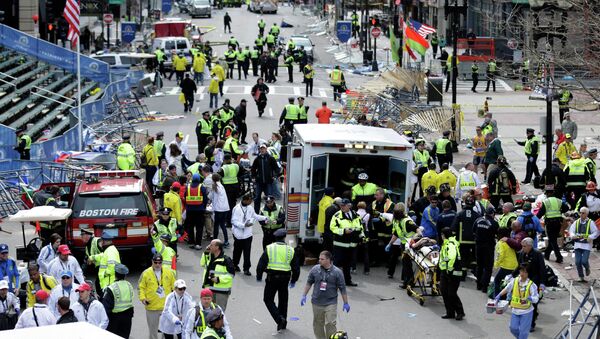 Medical workers aid injured people at the finish line of the 2013 Boston Marathon following an explosion. - Sputnik International