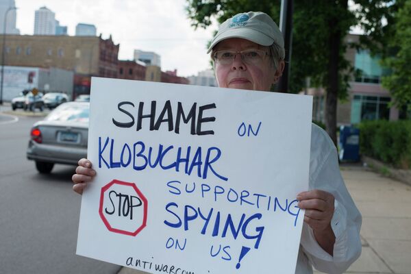 An anti-NSA spying activist protests Sen. Amy Klobuchar in Minneapolis. Klobuchar, who represents Minnesota, defended the NSA's collection of millions of phone records arguing they were not eavesdropping. - Sputnik International