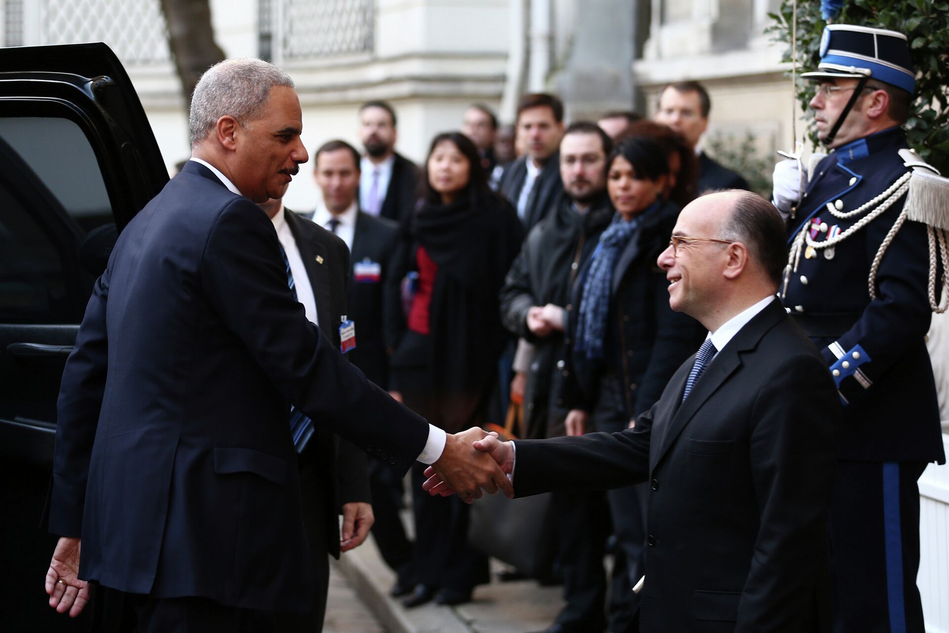 U.S Attorney General Eric Holder, left, is welcomed by French Interior Minister Bernard Cazeneuve before the start of an international meeting aimed at fighting terrorism, in Paris, France, Sunday, Jan. 11, 2015. A rally of defiance and sorrow, protected by an unparalleled level of security, on Sunday will honor the 17 victims of three days of bloodshed in Paris that left France on alert for more violence.  - Sputnik International, 1920, 29.12.2021