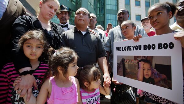 Alecia and Boun Khan Phonesavanh, from rear left, the parents of 19-month-old Bounkham Phonesavanh who was severely burned by a flash grenade during a SWAT drug raid, attend a vigil with their daughters outside Grady Memorial Hospital where he is undergoing treatment, Monday, June 2, 2014, in Atlanta. - Sputnik International