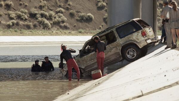 Los Angeles County Sheriff dive team members inspect the vehicle belonging to screenplay writer Gary DeVore who went missing June 28, 1997. The vehicle was found in the California Aqueduct in Palmdale, California, Wednesday, July 8, 1998. - Sputnik International