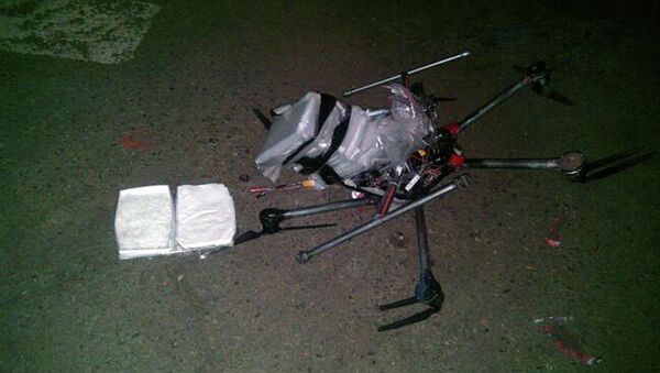In this image released by the Tijuana Municipal Police on Wednesday Jan. 21, 2015, a drone loaded with packages containing methamphetamine lies on the ground after it crashed into a supermarket parking lot in the city of Tijuana on Tuesday Jan. 20, 2015. - Sputnik International