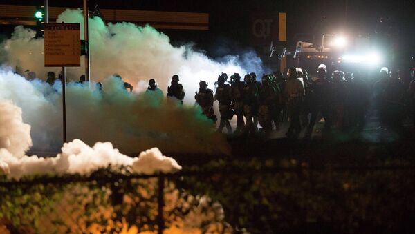 Riot police clear a street with smoke bombs while clashing with demonstrators in Ferguson, Missouri August 13, 2014. - Sputnik International