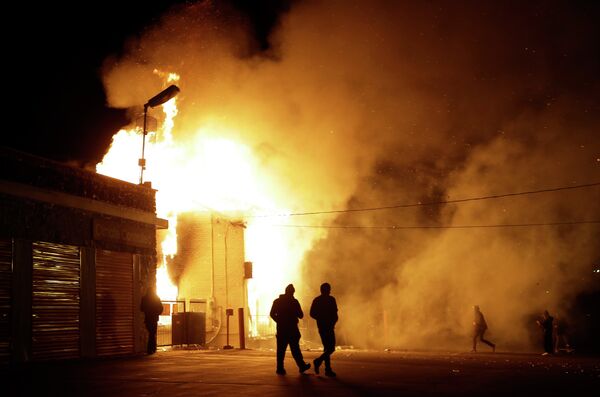 People walk away from a storage facility on fire after the announcement of the grand jury decision to not indict in Ferguson, Mo. People walk away from a storage facility on fire after the announcement of the grand jury decision to not indict in Ferguson, Mo. - Sputnik International