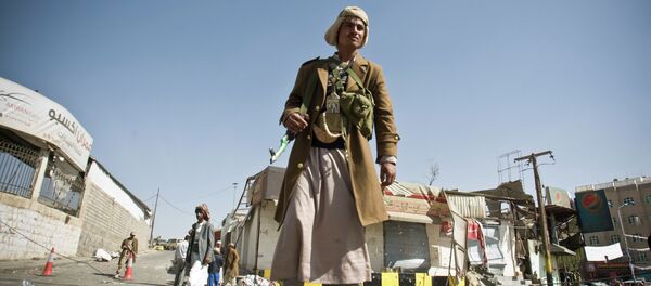 A Houthi Shiite Yemeni stands guard in front of a building damaged during recent clashes near the presidential palace in Sanaa, Yemen, Tuesday, Jan. 20, 2015. A Houthi Shiite Yemeni stands guard in front of a building damaged during recent clashes near the presidential palace in Sanaa, Yemen, Tuesday, Jan. 20, 2015. - Sputnik International