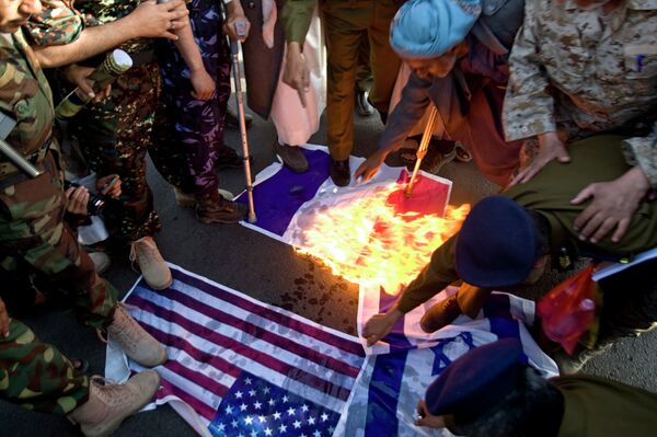 Yemeni protesters burn representations of French, American and Israeli flags during a demonstration to show their support for Houthi Shiite rebels in Sana'a. Prior to the official suspension of operations, the political situation in Yemen had already deteriorated and hampered intelligence gathering capabilities for US-led, Yemeni-manned raids against AQAP targets.  - Sputnik International