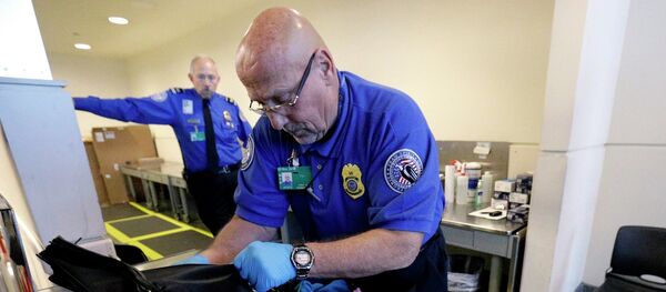 A TSA agent checks a bag at a security checkpoint area at Midway International Airport, Friday, Nov. 21, 2014, in Chicago. - Sputnik International