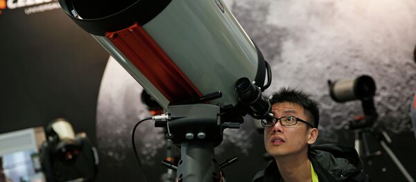Kei Yuen Hung looks through a telescope at the Celestron booth during the International CES Friday, Jan. 9, 2015, in Las Vegas. Kei Yuen Hung looks through a telescope at the Celestron booth during the International CES Friday, Jan. 9, 2015, in Las Vegas. - Sputnik International