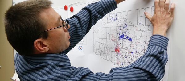 In this June 26, 2014 file photo, Austin Holland, research seismologist at the Oklahoma Geological Survey, hangs up a chart depicting earthquake activity at their offices at the University of Oklahoma in Norman, Okla. A study published Thursday, July 3, 2014 by the journal Science explains how just four wells forcing massive amounts of drilling wastewater into the ground are probably causing quakes in Oklahoma. The wells seem to have triggered more than 100 small-to-medium earthquakes in the past five years, according to a study. In this June 26, 2014 file photo, Austin Holland, research seismologist at the Oklahoma Geological Survey, hangs up a chart depicting earthquake activity at their offices at the University of Oklahoma in Norman, Okla. A study published Thursday, July 3, 2014 by the journal Science explains how just four wells forcing massive amounts of drilling wastewater into the ground are probably causing quakes in Oklahoma. The wells seem to have triggered more than 100 small-to-medium earthquakes in the past five years, according to a study. - Sputnik International