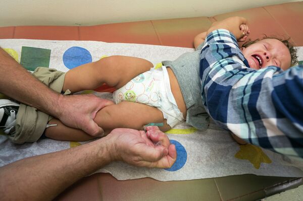 Pediatrician Charles Goodman vaccinates 1 year- old Cameron Fierro with the measles-mumps-rubella vaccine, or MMR vaccine at his practice in Northridge, Calif., Thursday, Jan. 29, 2015. Some doctors are adamant about not accepting patients who don't believe in vaccinations, with some saying they don't want to be responsible for someone's death from an illness that was preventable. Others warn that refusing treatment to such people will just send them into the arms of quacks.  - Sputnik International