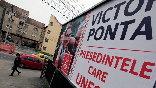 A woman walks past a banner of presidential candidate Victor Ponta, Romania's Prime Minister and leader of ruling leftist coalition, a day before the country's presidential elections in Sibiu November 1, 2014. - Sputnik International