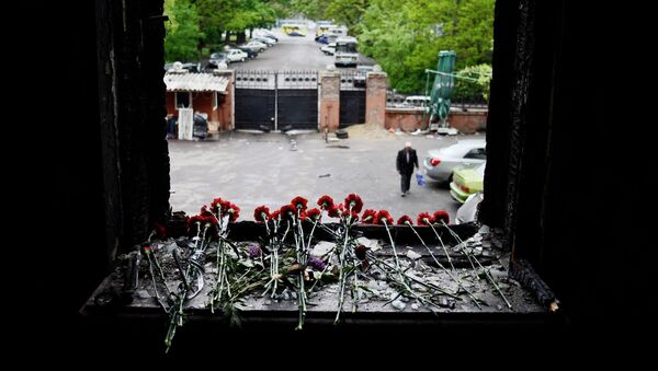 Flowers on a broken window in memory of the people killed by fire in the Trade Unions House on Odessa's Kulikovo Field Square. - Sputnik International