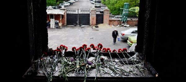 Flowers on a broken window in memory of the people killed by fire in the Trade Unions House on Odessa's Kulikovo Field Square. Flowers on a broken window in memory of the people killed by fire in the Trade Unions House on Odessa's Kulikovo Field Square. - Sputnik International