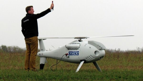 A member of the Organisation for Security and Cooperation in Europe's (OSCE) takes part in a demonstration test launching of a drone aircraft, which is expected to observe the situation in eastern regions of Ukraine, near the southern coastal town of Mariupol, October 23, 2014 - Sputnik International