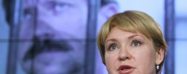 Alla Bout stands in front of a photograph of her imprisoned husband Viktor Bout Alla Bout stands in front of a photograph of her imprisoned husband Viktor Bout - Sputnik International