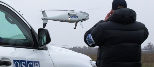 A member of the Organization for Security and Co-operation in Europe (OSCE) mission to Ukraine watches a drone take off during a test flight near the town of Mariupol, eastern Ukraine, Thursday, Oct. 23, 2014 A member of the Organization for Security and Co-operation in Europe (OSCE) mission to Ukraine watches a drone take off during a test flight near the town of Mariupol, eastern Ukraine, Thursday, Oct. 23, 2014 - Sputnik International