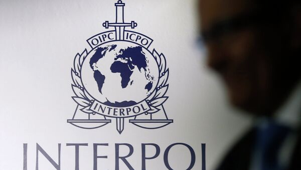 A man passes an Interpol logo during the handing over ceremony of the new premises for Interpol's Global Complex for Innovation, a research and development facility, in Singapore September 30, 2014 - Sputnik International