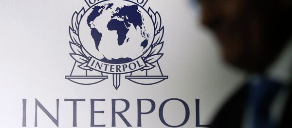 A man passes an Interpol logo during the handing over ceremony of the new premises for Interpol's Global Complex for Innovation, a research and development facility, in Singapore September 30, 2014 A man passes an Interpol logo during the handing over ceremony of the new premises for Interpol's Global Complex for Innovation, a research and development facility, in Singapore September 30, 2014 - Sputnik International