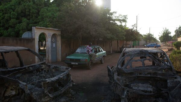 A taxi driver sits in front of the ransacked home of a member of parliament belonging to the ex-president Blaise Compaore's political party in Ouagadougou, capital of Burkina Faso, November 3, 2014 - Sputnik International