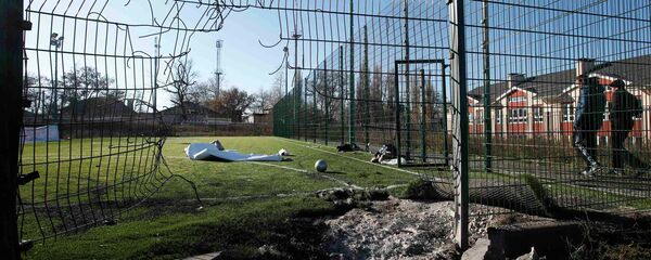 A crater caused by shelling is seen near a school's soccer field in Donetsk, eastern Ukraine, November 6, 2014 - Sputnik International