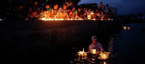Typhoon survivors light candles to commemorate the victims who perished during the onslaught of Typhoon Haiyan a year ago in Tacloban city Typhoon survivors light candles to commemorate the victims who perished during the onslaught of Typhoon Haiyan a year ago in Tacloban city - Sputnik International