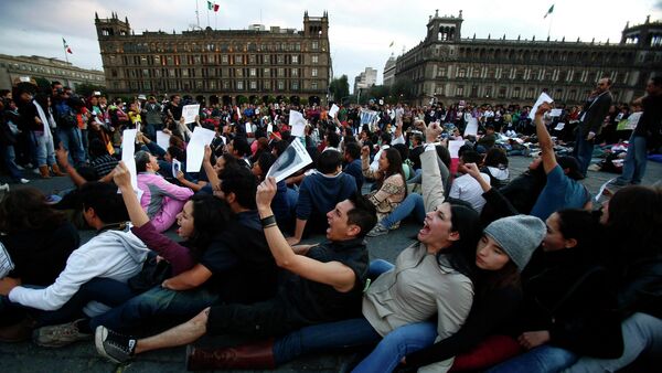 Demonstrators sit on the floor during a protest in support of the missing Ayotzinapa Teacher Training College Raul Isidro Burgos students at Zocalo square in Mexico City. - Sputnik International